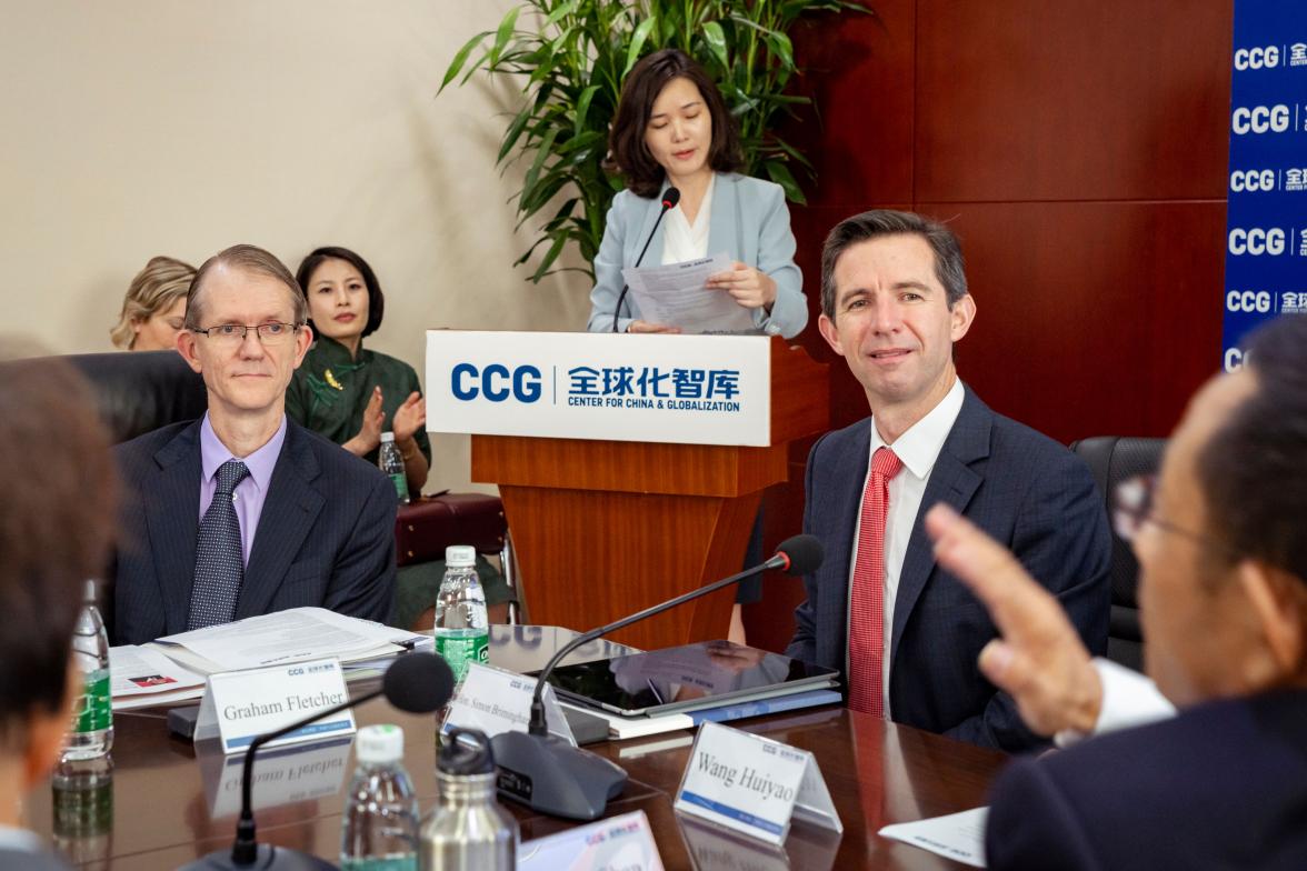 Photo of Simon Birmingham and Graham Fletcher sitting at a table listening to a speaker.