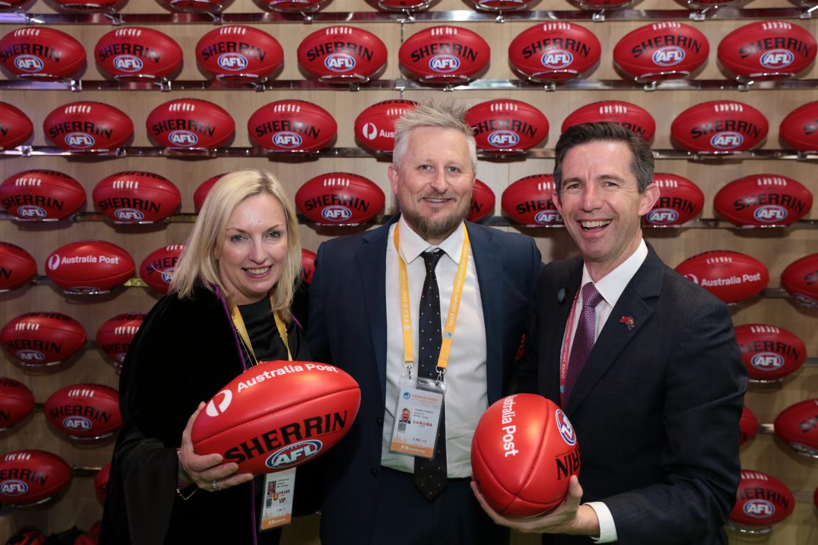 Trade, Tourism and Investment Minister Simon Birmingham with Australia Post CEO Christine Holgate and AFL Head of China Tom Parker. Simon and Christine are holding AFL balls for the photo. 