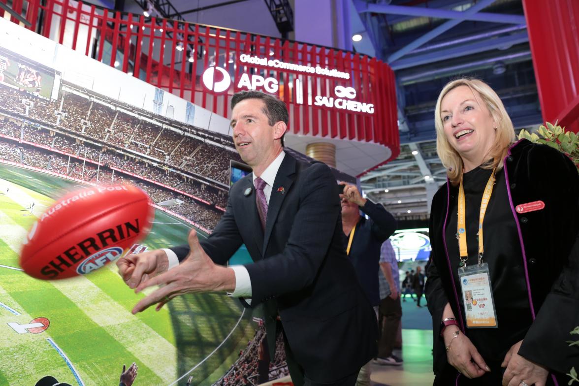 Trade, Tourism and Investment Minister Simon Birmingham and Australia Post CEO Christine Holgate participating and a handball game with an AFL ball. 