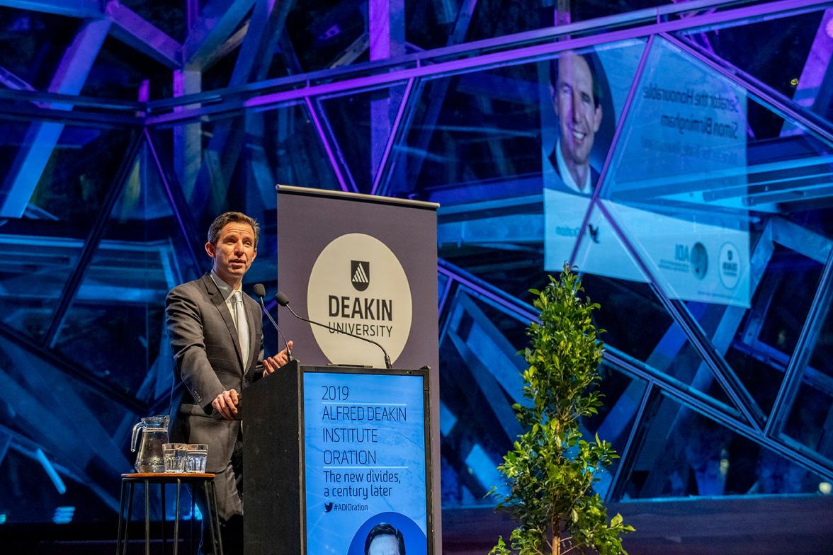 Photo of Minister Birmingham on stage delivering a speech at the 2019 Alfred Deakin Institute Oration.