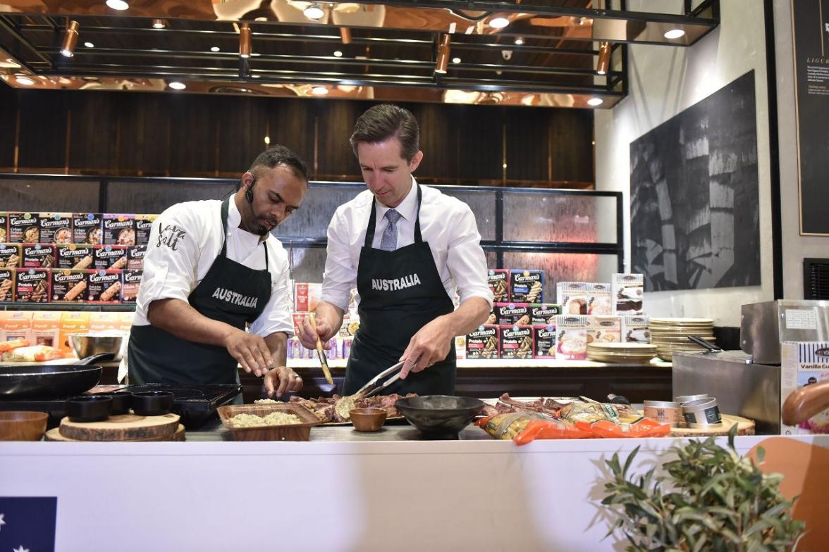 Photo of Minister Simon Birmingham assisting Melbourne chef Sebastian Simon in the kitchen.