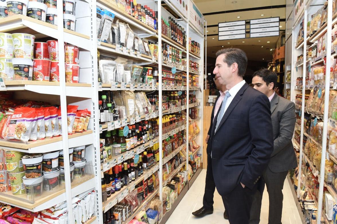 Photo of Minister Simon Birmingham looking at shelves of food.