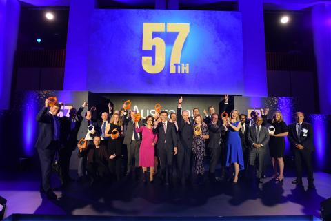 Group photo of Minister Birmingham with the 2019 winners for the 57th Australian Export Awards on stage, with the numbers 57 on the big screen in the background. 